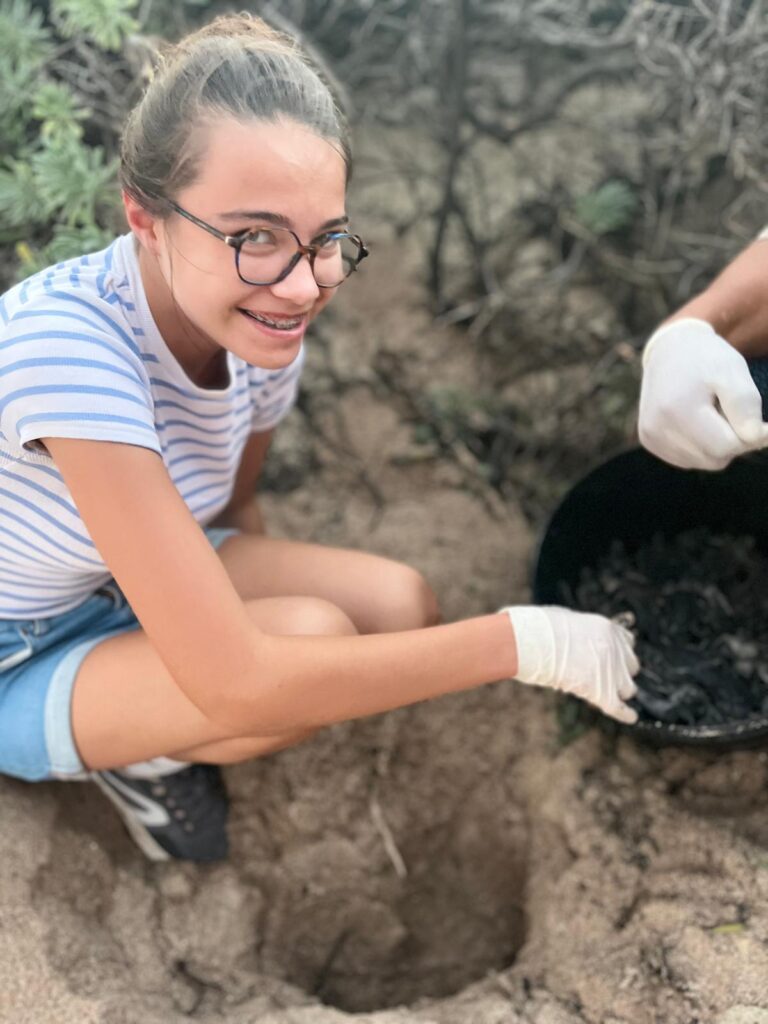 Jeune ado protégeant un nid de bébés tortues